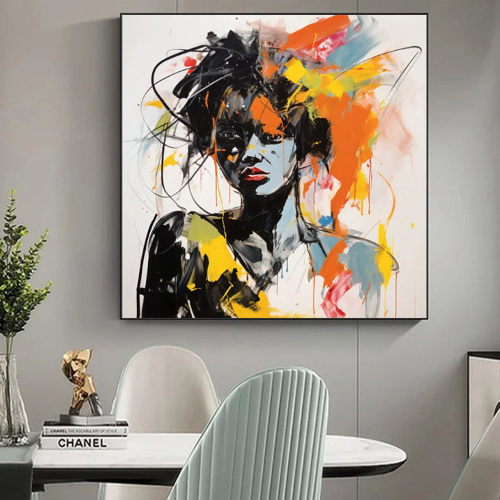 Abstract painting of a woman's face on a wall above a table with decor items.

